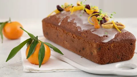 A fruitcake soaked in rum is on the table. Christmas atmosphere with lanterns in Stock Footage 145367818