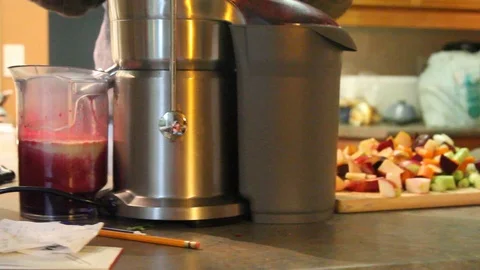 Fruits and vegetables get processed through a juicer Video stock 96702552