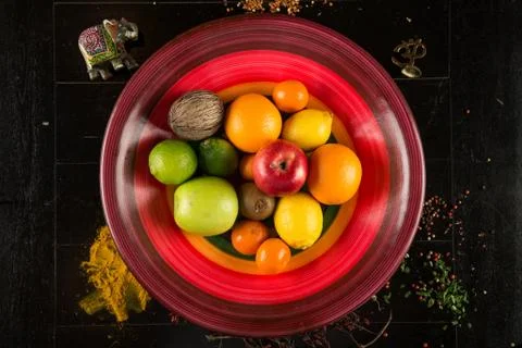 Fruits and vegetables lie in a plate top view Photos