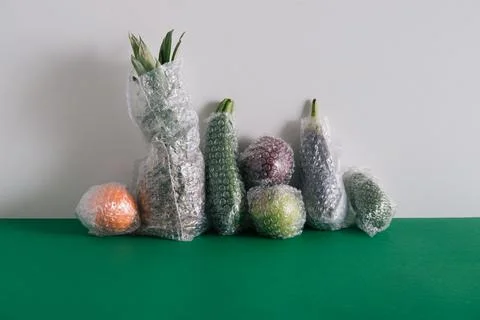 Fruits and vegetables packaged in plastic wrap Stock Photos