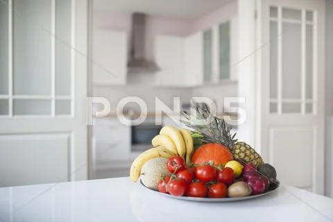 Fruits And Vegetables In Plate On Table At Home