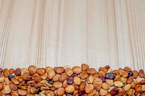 The fruits of the beans lie on a light background of a wooden table. Backgrou Stock Photos