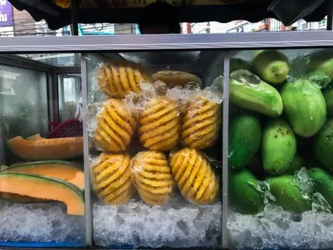 Fruits (Melon, pineapple and mango) in glass case with ice for sell, Thailand Stock Photos