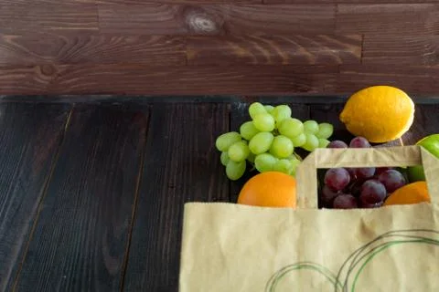 Fruits in a paper bag. orange, lemon, apple, grapefruit, grapes Stock Photos