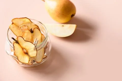 Fruits pattern of fresh pear and dry chips on a beige background. Vegan des.. Stock Photos