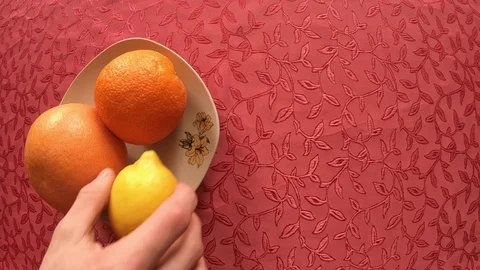 Fruits on a plate (adding a lemon to grapefruit and orange) Stock Footage 86944564