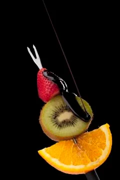 Fruits on the stick with chocolates Stock Photos