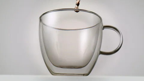 Fruity hot tea softly being poured into a glass in slowmotion Video stock 99700639