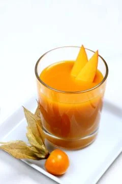 Fruity mango smoothie with physalis Stock Photos