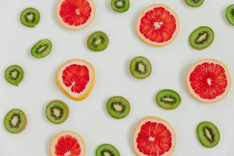 Fruity pattern of kiwi and grapefruit slices on the white background. Top v.. Stock Photos