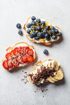 Fruity vegetarian toasts for breakfast on gray background. Bread slices wit.. Stock Photos