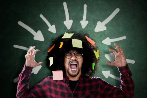 Frustrated Afro man under arrows over his head Stock Photos
