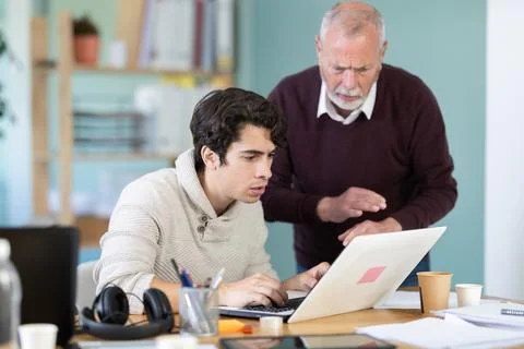 Frustrated and discouraged men in front of laptop in office workplace Stock Photos