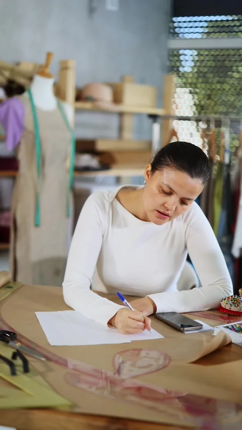 Frustrated and puzzled dressmaker with documents in her hands stands in front of Stock Footage 329540055