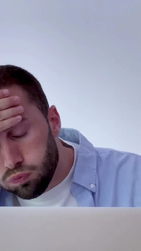 Frustrated and tired freelancer working on a laptop, feeling overwhelmed Stock Footage 345077828