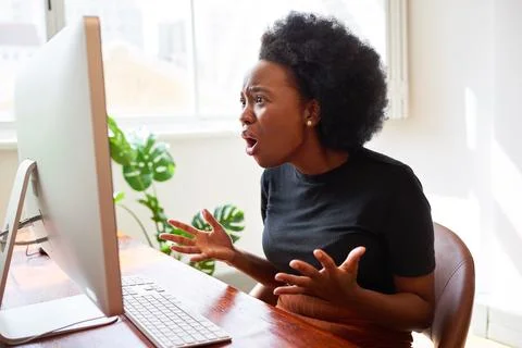 Frustrated and upset young developer shouts at screen, Black woman in tech Stock Photos