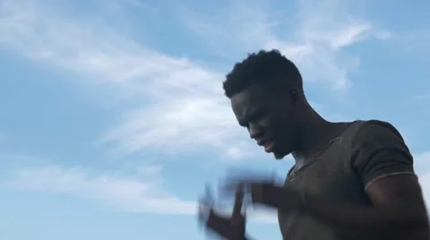 A frustrated black guy shouting at cloudy and windy area Stock Footage 67556459