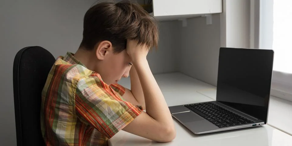 Frustrated boy experiencing difficulty while studying at home Fotos de archivo