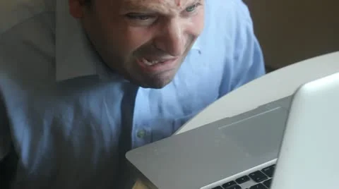 Frustrated business man bites his laptop Stock Footage