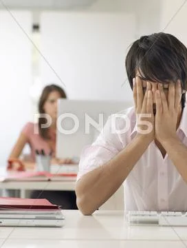 Frustrated Businessman With Hands On Face At Desk Stock Photos