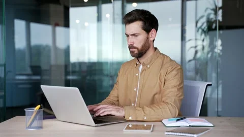 Frustrated businessman having difficulty making transaction using laptop while  Stock Footage 295038727