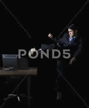 Frustrated businessman kicking a desktop pc Stock Photos