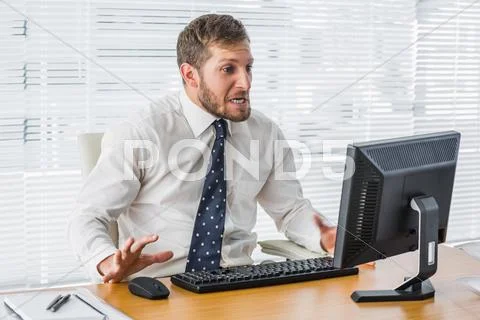 Frustrated businessman looking at his computer Stock Photos