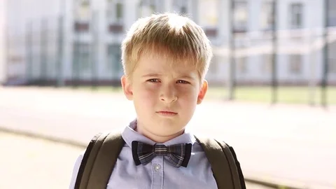  A frustrated child in the background of the school. A sad schoolboy.  Stock Footage 79168182