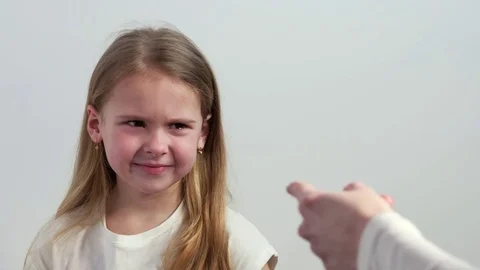 A frustrated child cries while looking at the hand of an adult Stock Footage 73644726