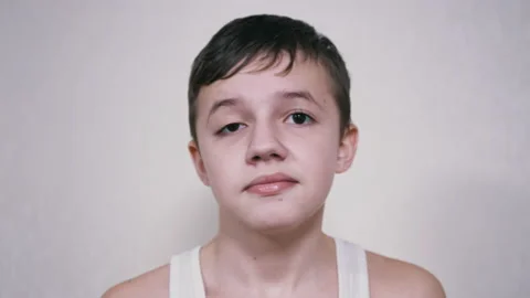 Frustrated Child Hits Himself in the Face with Palm. 4K. Close up. Slow motion Stock Footage 173292759