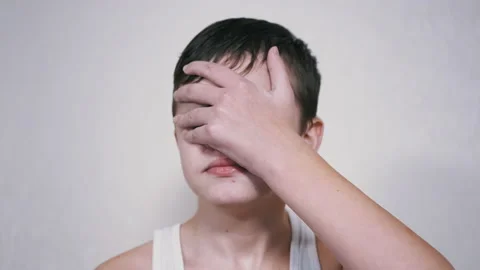 Frustrated Child Hits Himself in the Face with Palm. 4K. Close up. Slow motion Stock Footage 173293245
