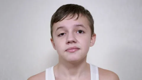 Frustrated Child Hits Himself in the Face with Palm. 4K. Close up. Slow motion Stock Footage 173307680