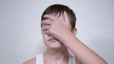 Frustrated Child Hits Himself in the Face with Palm. 4K. Close up. Slow motion Stock Footage 173318405
