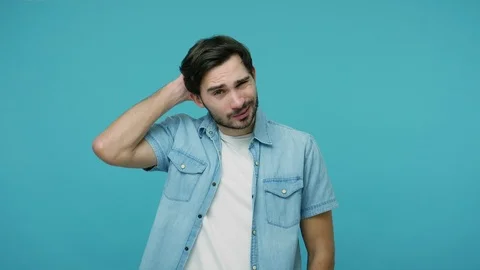 Frustrated confused young bearded guy in jeans shirt scratching head Stock Footage 126074883