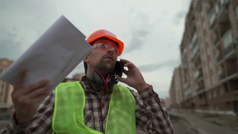 Frustrated construction foreman talking with an employee on his cell phone Stock Footage 156254786