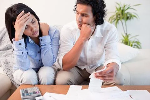 Frustrated couple checking their bills Stock Photos