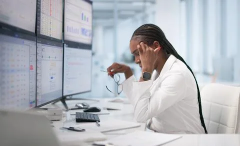 Frustrated Doctor Sitting At Desk Using Computer To Manage Patient Spreadshee Stock Photos