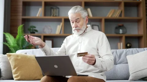 Frustrated elderly senior man discovered fraud while entering credit card number Stock Footage 256710370