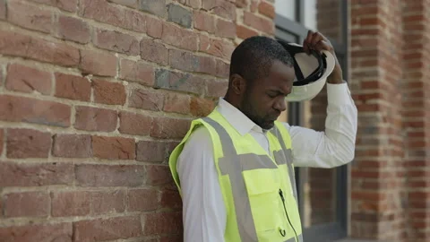 Frustrated engineer taking off helmet while standing outdoor Video stock 197081112