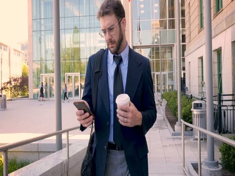 Frustrated executive millennial businessman walking and using smart phone in 4k Stock Footage