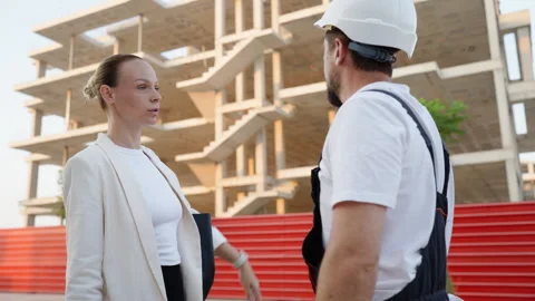 Frustrated female architect arguing with a construction foreman holding blu.. Stock Footage 341334411