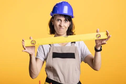 Frustrated female builder questioning accuracy of measuring level Stock Photos