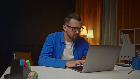 Frustrated freelancer sitting at desk with computer nervously looking at screen Stock Footage 169998998
