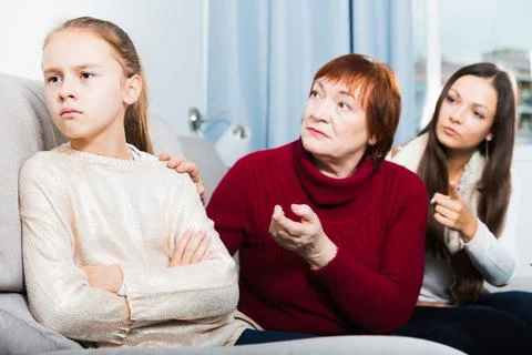 Frustrated girl while mother and grandmother berating her Stock Photos