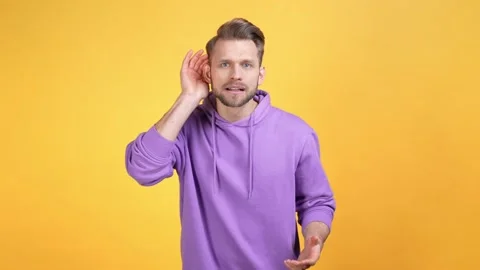 Frustrated guy cant hear conspiracy isolated bright color background Stock Footage 169511135