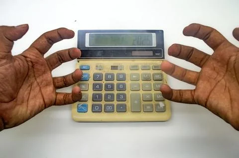 Frustrated hands hovering over a calculator. Concept of financial stress, d.. Stock Photos