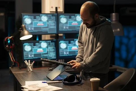 Frustrated male developer angrily hitting laptop with computer keyboard 写真素材