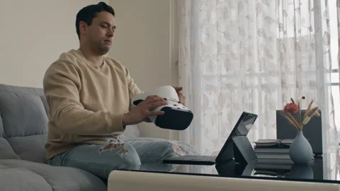 Frustrated man coding and testing VR headset. Engineer testing project on Stock Footage 310329803