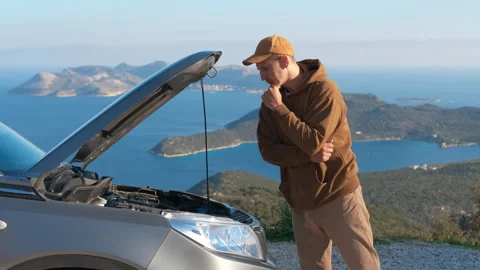 Frustrated man looking at his broken down car engine. Stock Footage 332927354