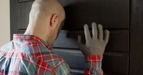 Frustrated man presses bold head against cold surface of door Vidéo 314716987